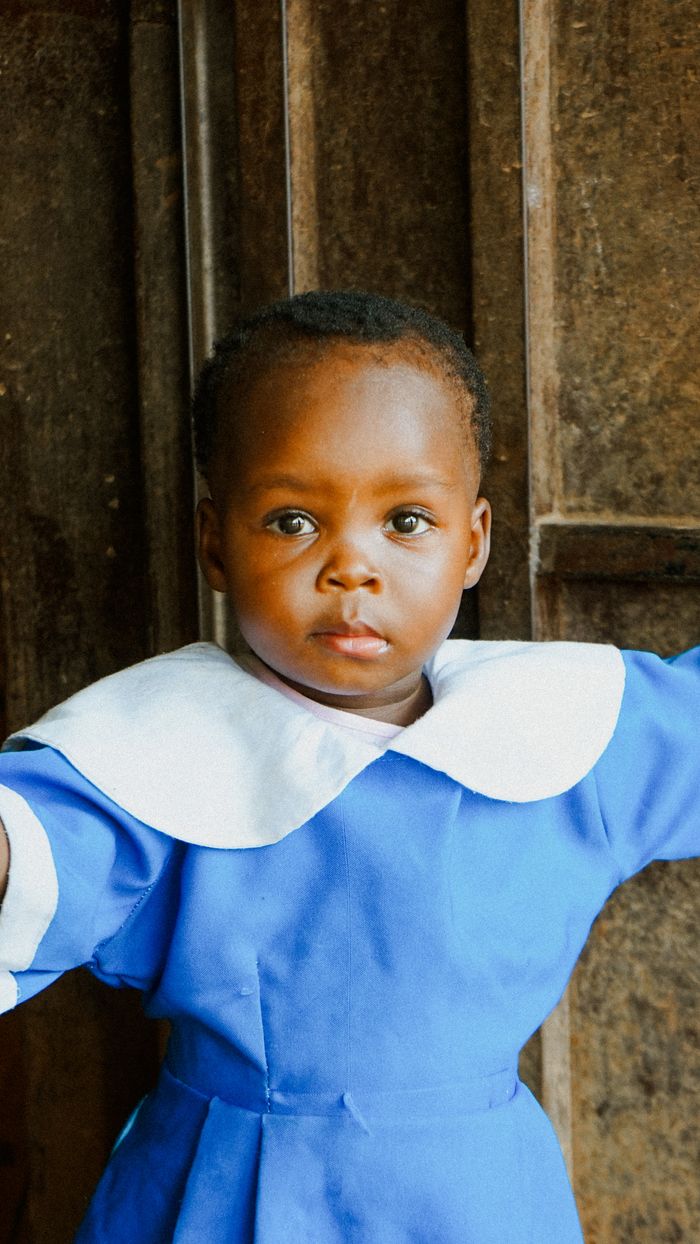 Crafting Captivating Headlines: Your awesome post title goes here Charming portrait of a young child in a classic blue school uniform with a white collar.